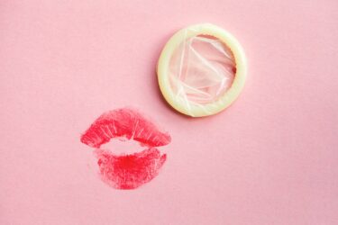 Zu sehen sind ein Lippenstiftabdruck eine Mundes und ein Kondom. Bildunterschrift: Oralsex als Infektionsrisiko: Viele junge Menschen fühlen sich schlecht über die Risiken und mögliche Maßnahmen zur Verringerung des Übertragungsrisikos, wie z. B. Kondome, informiert. (Foto © zakalinka – adobestock)