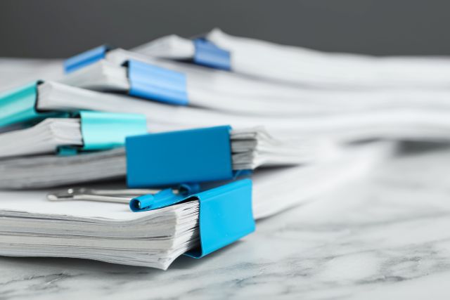 Mehrere Papierstapel. Etwa 90 % der klinischen Studien erreichen ihre Rekrutierungsziele nicht. Probando will das ändern. (Foto: Adobe Stock)