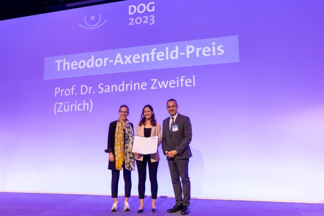 Drei Personen auf einer Bühne bei der Theodor-Axenfeld-Preisverleihung im Rahmen der DOG 2023