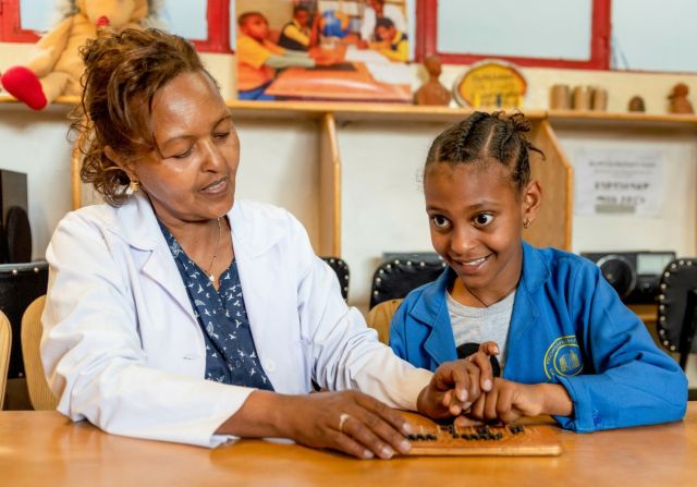 Blindes Mädchen ertastet Braille-Schrift