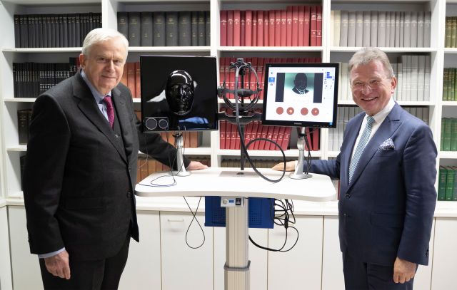 zwei Männer stehen neben dem Eyesi-Simulator