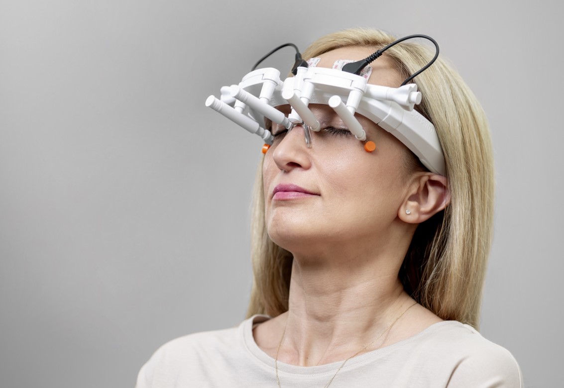 Frau mit am Kopf befestigtem Therapiesystem OkuStim2