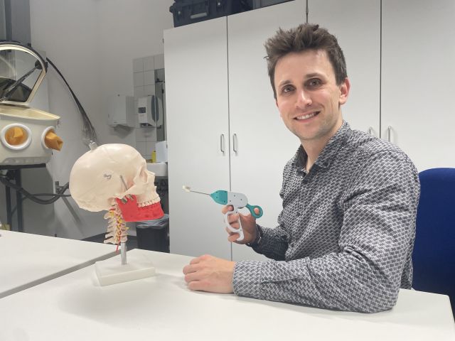 Entwickler zeigt Schädelmodell mit Implantationssystem