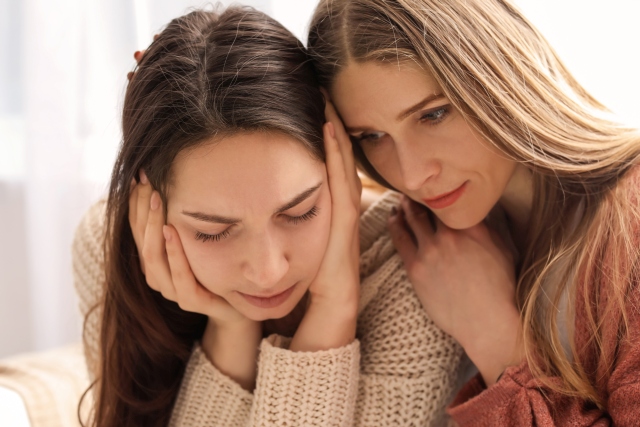Zwei Personen in gemütlicher Kleidung, die eng beieinander sitzen und eine emotionale Verbindung zeigen.
