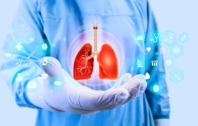 Arzt in blauer Kleidung hält eine digitale Darstellung von Lungen mit medizinischen Symbolen im Hintergrund