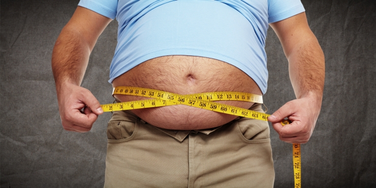 Symbolbild, übergewichtiger Mann misst seinen Bauchumfang