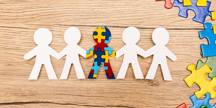 Kinder dargestellt als Papierfiguren, Kind mit Autismus als buntes Puzzle zwischen weißen Papierfiguren