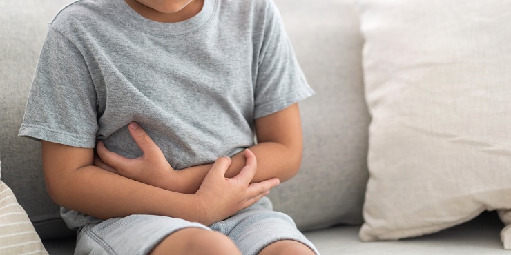 Kind mit Bauchschmerzen hält sich die Hände an den Bauch