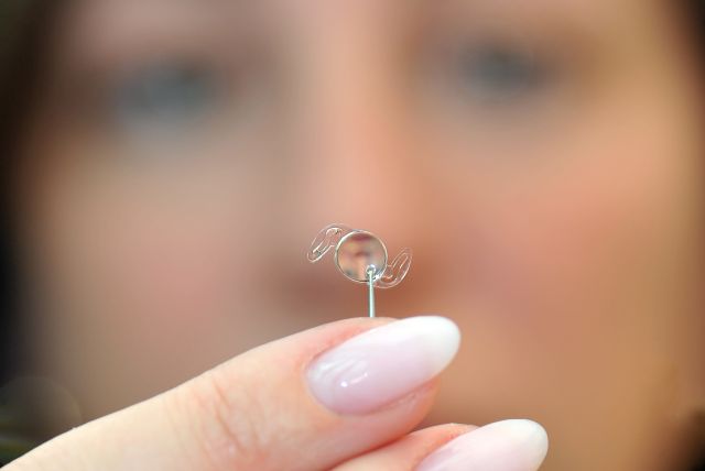 Frau präsentiert IOL auf dem Finger