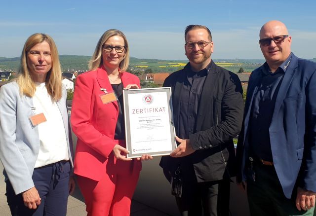 Gruppenbild auf Dachterrasse mit Zertifikat