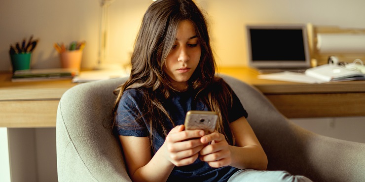 Teenager Mädchen blickt auf sein Smartphone