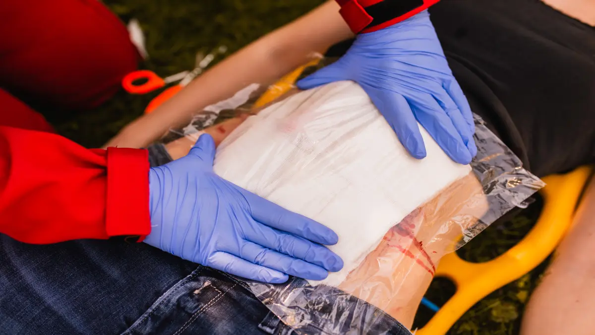 Ein Sanitäter demonstriert die Versorgung einer Bauchverletzung bei einer Frau nach einem Autounfall.