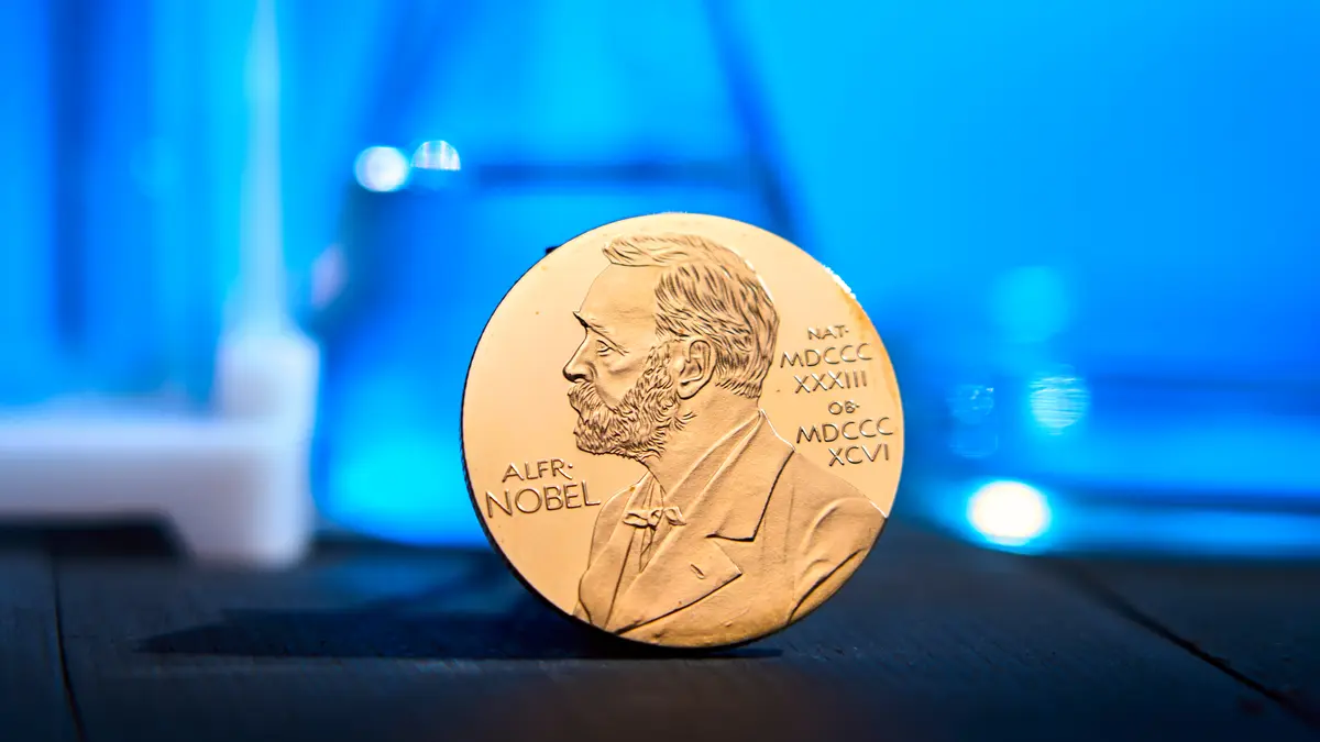 Dieses Bild zeigt die Nobelpreis-Medaille vor einem wissenschaftlichen Hintergrund. Es illustriert die Verleihung des Medizin-Nobelpreises 2025 für die Forschung zu regulatorischen T-Zellen und deren Bedeutung für die Immuntherapie.