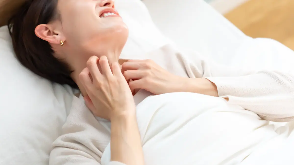 Frau im Bett mit plötzlicher Juckreiz am ganzen Körper ohne Ausschlag