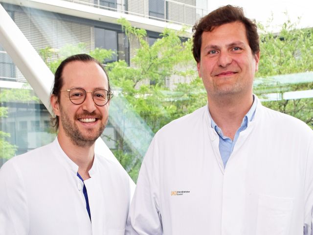 Zwei Ärzte in weißen Kitteln vor einem modernen Klinikgebäude, die an einer Omega-3-Studie beteiligt sind.