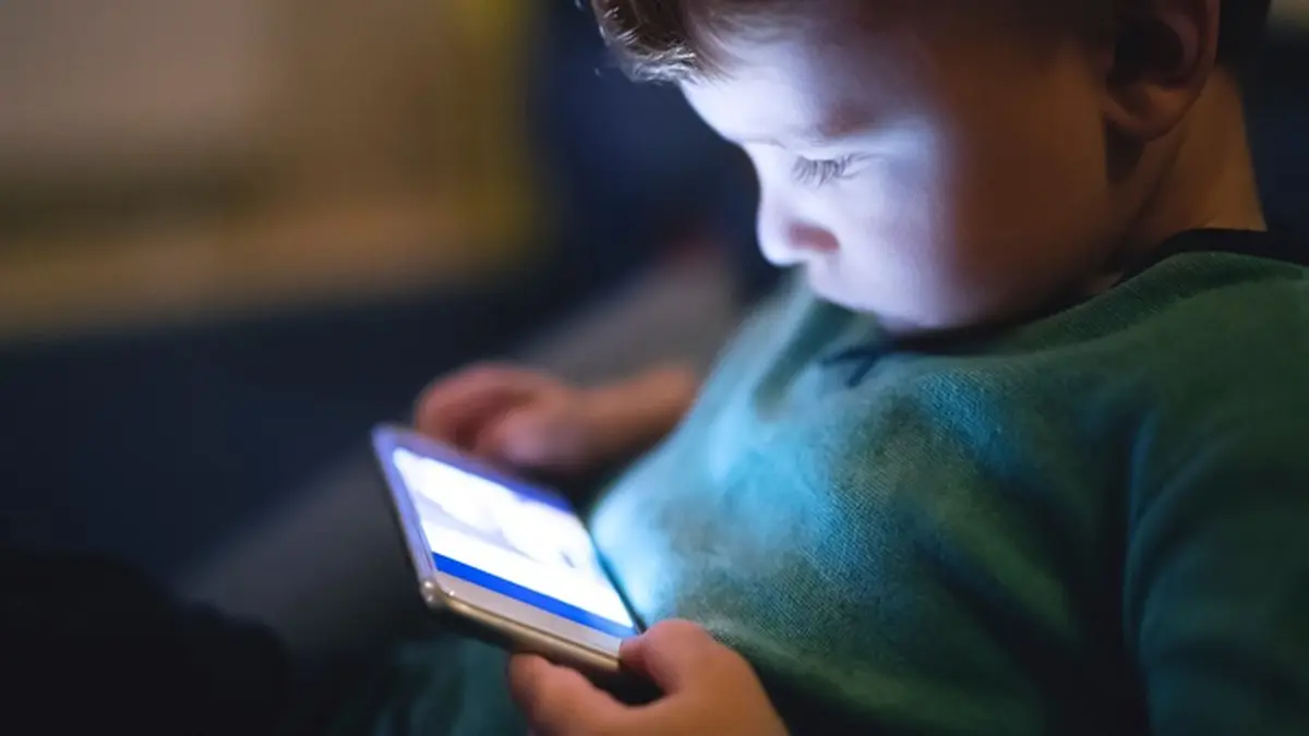 Kleines Kind sieht sich auf einem Smartphone etwas an