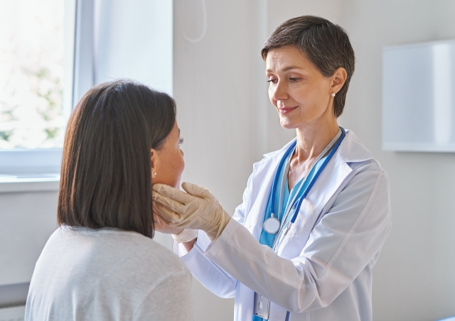 Ärztin untersucht eine Patientin in einer klinischen Umgebung, symbolisch für medizinische Versorgung und Betreuung.