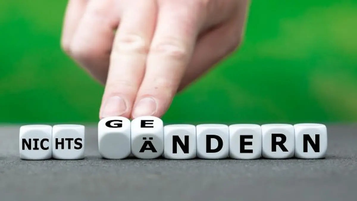 Weiße Würfel mit den Worten „nichts ändern“ und „geändert“, die Entscheidung und Veränderung symbolisieren.