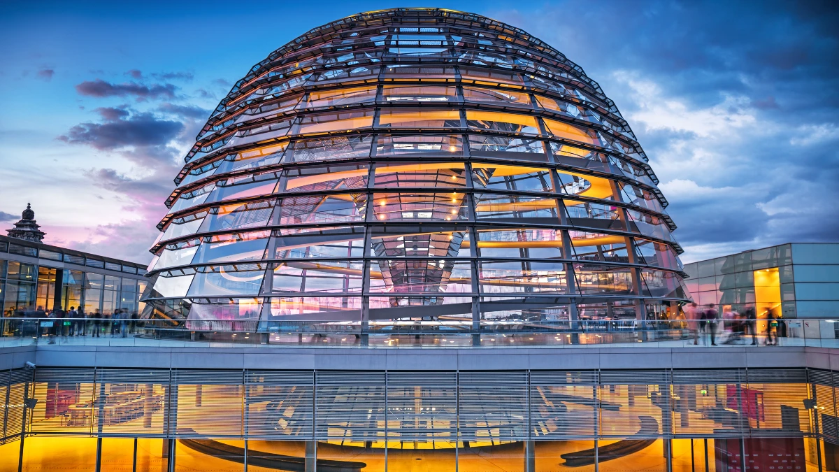 Die Reichstagskuppel des Deutschen Bundestages in Berlin, erleuchtet in der Dämmerung