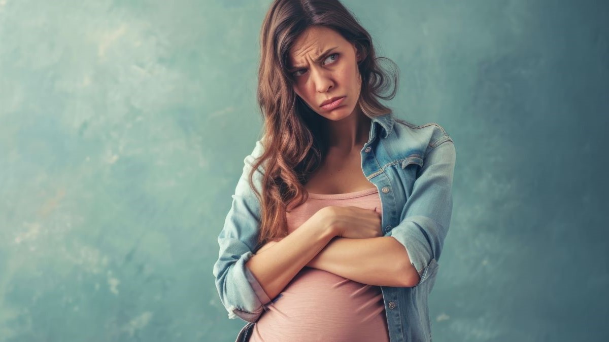 Schwangere Frau in einem Jeanshemd, Symbol für Schwangerschaft und Gesundheit.