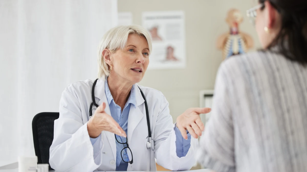 Ärztin spricht stark gestikulierend mit einer Patientin